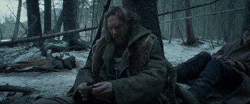 Movie still from “The Revenant” (2015), directed by Alejandro G. Iñárritu – A man with a beard and a fur coat holding an axe; Medium shot, Low angle