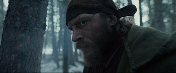 Movie still from “The Revenant” (2015), directed by Alejandro G. Iñárritu – A person with a beard wearing a hat; Close Up shot, Over the shoulder angle