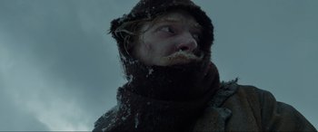 Movie still from “The Revenant” (2015), directed by Alejandro G. Iñárritu – A man with a beard is wearing a scarf; Close Up shot, Low angle