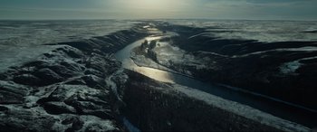 Movie still from “The Revenant” (2015), directed by Alejandro G. Iñárritu – A view of a river with a lot of snow on the banks; Extreme Wide shot, High angle