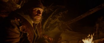 Movie still from “The Revenant” (2015), directed by Alejandro G. Iñárritu – A man with long hair and a beard wearing a brown hat; Medium shot, Low angle