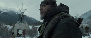 Movie still from “The Revenant” (2015), directed by Alejandro G. Iñárritu – A person in a field with a mountain in the background; Close Up shot, Low angle