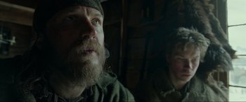 Movie still from “The Revenant” (2015), directed by Alejandro G. Iñárritu – A man with a long beard and a man with long hair; Close Up shot, Low angle