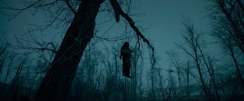Movie still from “The Revenant” (2015), directed by Alejandro G. Iñárritu – A person hanging from a tree in the dark; Wide shot, Low angle