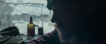 Movie still from “The Revenant” (2015), directed by Alejandro G. Iñárritu – A man with a beard is looking out a window; Close Up shot, Over the shoulder angle