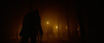 Movie still from “The Revenant” (2015), directed by Alejandro G. Iñárritu – A man riding a horse through a forest at night; Wide shot, Low angle