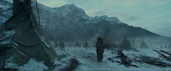Movie still from “The Revenant” (2015), directed by Alejandro G. Iñárritu – A group of people standing on top of a snow covered field; Extreme Wide shot, Low angle