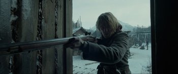 Movie still from “The Revenant” (2015), directed by Alejandro G. Iñárritu – A woman holding a gun in her hand; Medium shot, Over the shoulder angle