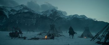 Movie still from “The Revenant” (2015), directed by Alejandro G. Iñárritu – A group of people sitting around a fire in the snow; Extreme Wide shot, Low angle