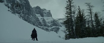 Movie still from “The Revenant” (2015), directed by Alejandro G. Iñárritu – A person riding a horse on a snowy slope; Extreme Wide shot, Low angle