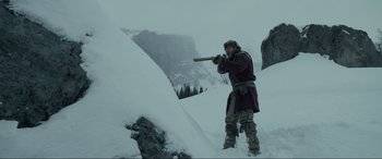 Movie still from “The Revenant” (2015), directed by Alejandro G. Iñárritu – A man standing on top of a snow covered slope; Wide shot, Low angle