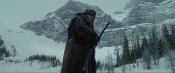 Movie still from “The Revenant” (2015), directed by Alejandro G. Iñárritu – A man in a bear coat holding a rifle in the snow; Wide shot, Low angle