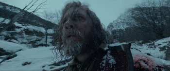 Movie still from “The Revenant” (2015), directed by Alejandro G. Iñárritu – A man with long hair and a beard in the snow; Close Up shot, Low angle