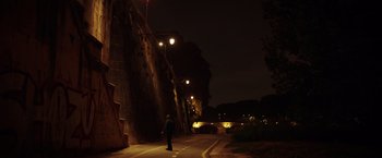Movie still from “The Ritual Killer” (2023), directed by George Gallo – A person standing on a street at night; Extreme Wide shot, Low angle