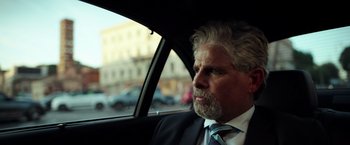 Movie still from “The Ritual Killer” (2023), directed by George Gallo – A person wearing a suit in a car; Close Up shot, Over the shoulder angle