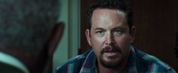 Movie still from “The Ritual Killer” (2023), directed by George Gallo – A person wearing a plaid shirt; Close Up shot, Over the shoulder angle