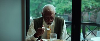 Movie still from “The Ritual Killer” (2023), directed by George Gallo – An older man sitting at a table with a fork in his hand; Close Up shot, Low angle