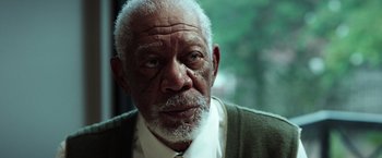 Movie still from “The Ritual Killer” (2023), directed by George Gallo – An older man wearing a white shirt and a green jacket; Close Up shot, Low angle