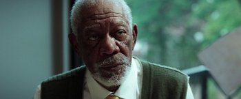 Movie still from “The Ritual Killer” (2023), directed by George Gallo – An older man wearing a suit and a tie; Close Up shot, Over the shoulder angle