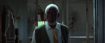 Movie still from “The Ritual Killer” (2023), directed by George Gallo – An older man wearing a white shirt and a yellow neck tie; Close Up shot, Low angle