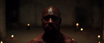 Movie still from “The Ritual Killer” (2023), directed by George Gallo – A person in a dark room; Close Up shot, High angle