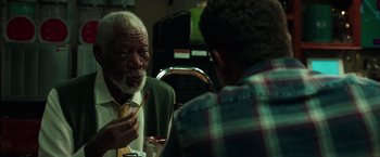 Movie still from “The Ritual Killer” (2023), directed by George Gallo – Two men are sitting at a table and one of them is holding a pen; Close Up shot, Over the shoulder angle