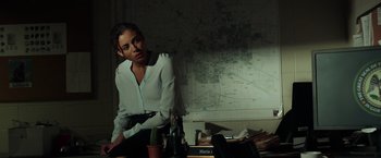 Movie still from “The Ritual Killer” (2023), directed by George Gallo – A woman sitting in front of a map; Medium shot, Over the shoulder angle