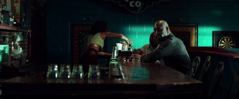 Movie still from “The Ritual Killer” (2023), directed by George Gallo – Two men and a woman sitting at a bar; Medium shot, Low angle