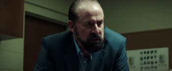 Movie still from “The Ritual Killer” (2023), directed by George Gallo – A person wearing a suit and beard; Close Up shot, Low angle