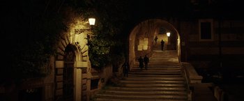 Movie still from “The Ritual Killer” (2023), directed by George Gallo – People are walking down a set of stairs at night; Extreme Wide shot, High angle