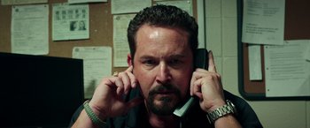 Movie still from “The Ritual Killer” (2023), directed by George Gallo – A person talking on a cell phone; Close Up shot, Low angle