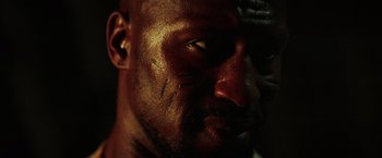 Movie still from “The Ritual Killer” (2023), directed by George Gallo – The face of a man with dirt all over his face; Extreme Close Up shot, Low angle