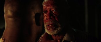Movie still from “The Ritual Killer” (2023), directed by George Gallo – An old man with a beard and a white shirt is looking at the camera; Close Up shot, Over the shoulder angle