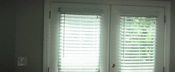 Movie still from “The Ritual Killer” (2023), directed by George Gallo – A white door with a window with blinds on the outside; Medium shot, Low angle