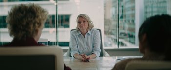 Movie still from “The Royal Hotel” (2023), directed by Kitty Green – A woman sitting at a table in front of a window; Medium shot, Over the shoulder angle