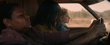 Movie still from “The Royal Hotel” (2023), directed by Kitty Green – Two women sitting in a car looking out the window; Medium shot, Over the shoulder angle