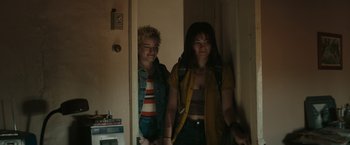 Movie still from “The Royal Hotel” (2023), directed by Kitty Green – Two young women standing next to each other in front of a door; Medium shot, Over the shoulder angle