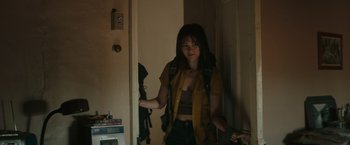 Movie still from “The Royal Hotel” (2023), directed by Kitty Green – A young woman is standing in the doorway of a house; Medium shot, Over the shoulder angle