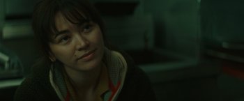 Movie still from “The Royal Hotel” (2023), directed by Kitty Green – A person sitting in a room; Close Up shot, Over the shoulder angle