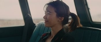 Movie still from “The Royal Hotel” (2023), directed by Kitty Green – A woman sitting in the back of a vehicle; Close Up shot, Over the shoulder angle