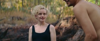 Movie still from “The Royal Hotel” (2023), directed by Kitty Green – A woman in a black top is smiling; Close Up shot, Over the shoulder angle