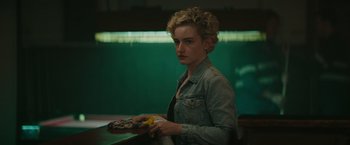 Movie still from “The Royal Hotel” (2023), directed by Kitty Green – A woman holding a plate of food in her hands; Close Up shot, Over the shoulder angle