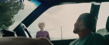 Movie still from “The Royal Hotel” (2023), directed by Kitty Green – A man with blonde hair is looking out a car window; Medium shot, Over the shoulder angle