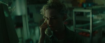 Movie still from “The Royal Hotel” (2023), directed by Kitty Green – A woman holding a phone to her ear; Close Up shot, Low angle