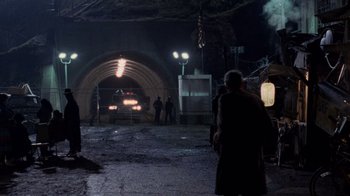 Movie still from “The Running Man” (1987), directed by Paul Michael Glaser – People are standing in a tunnel at night; Extreme Wide shot, High angle