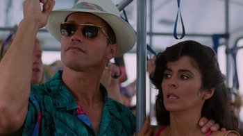 Movie still from “The Running Man” (1987), directed by Paul Michael Glaser – A man and a woman riding on a bus together; Close Up shot, Low angle