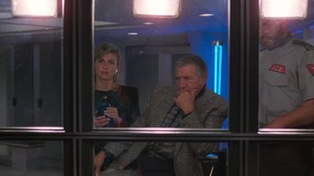 Movie still from “The Running Man” (1987), directed by Paul Michael Glaser – A man and a woman are looking in a mirror; Medium shot, Low angle