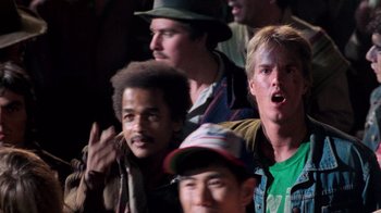 Movie still from “The Running Man” (1987), directed by Paul Michael Glaser – A group of men standing next to each other in a room; Close Up shot, Low angle