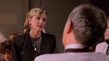 Movie still from “The Running Man” (1987), directed by Paul Michael Glaser – A woman is looking at a man in the mirror; Close Up shot, Over the shoulder angle