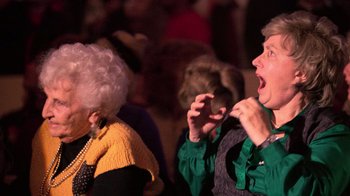 Movie still from “The Running Man” (1987), directed by Paul Michael Glaser – A man and a woman are singing together; Close Up shot, High angle